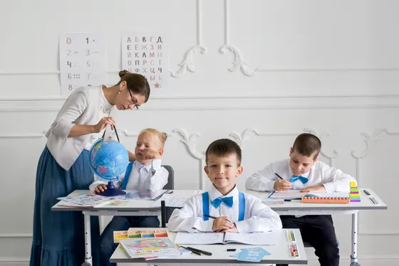 Педагог и ученики на занятии с глобусом
